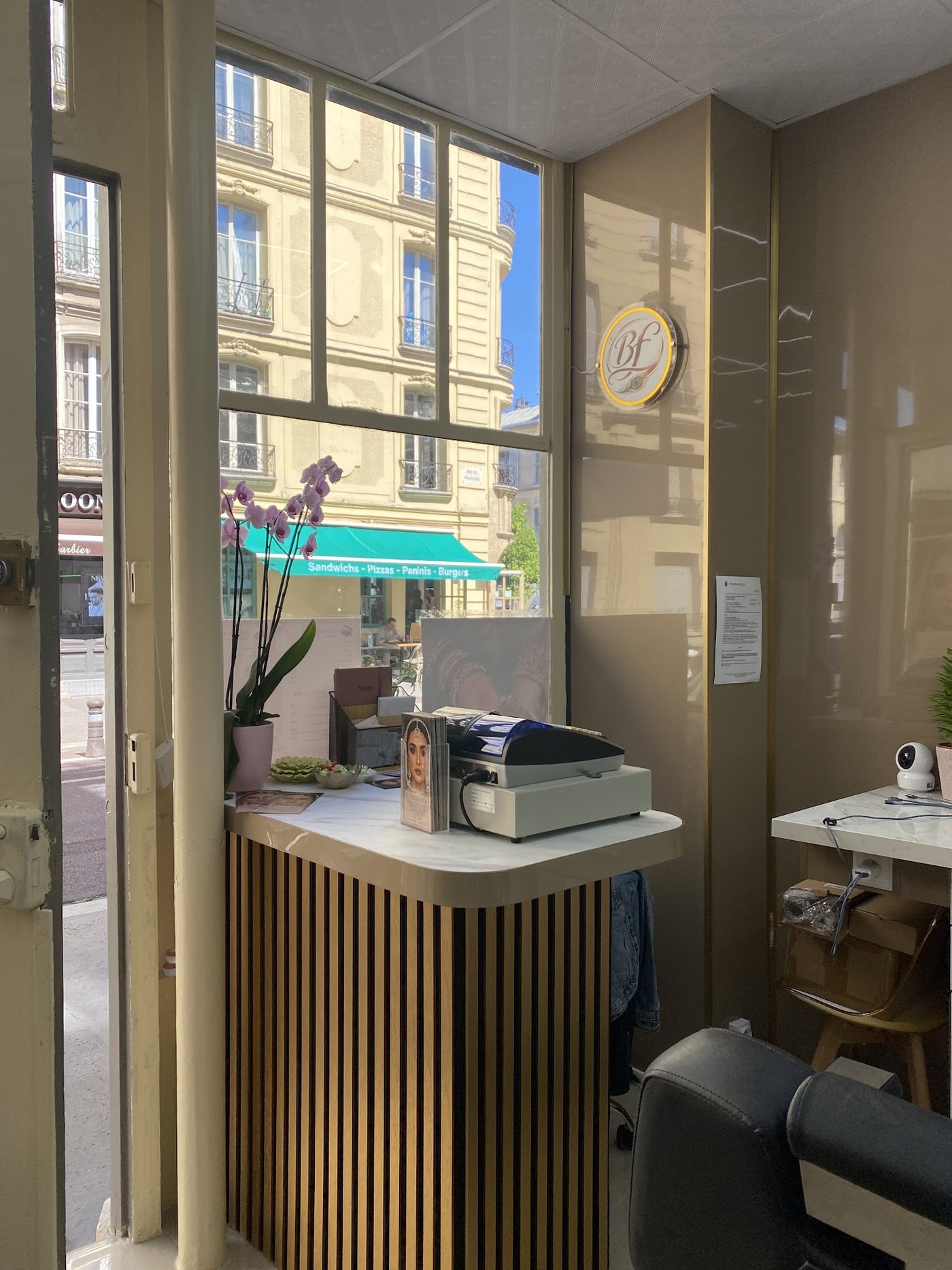 L'accueil de l'institut : le comptoir à tasseaux dorés et le médaillon « Bf » au mur
