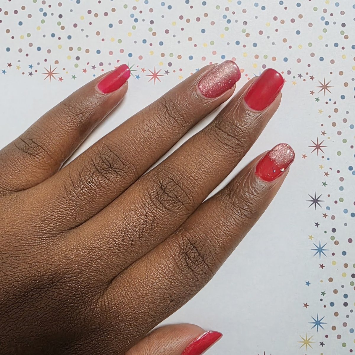 Une manucure réalisée à l'institut : vernis rouge et deux ongles pailletés